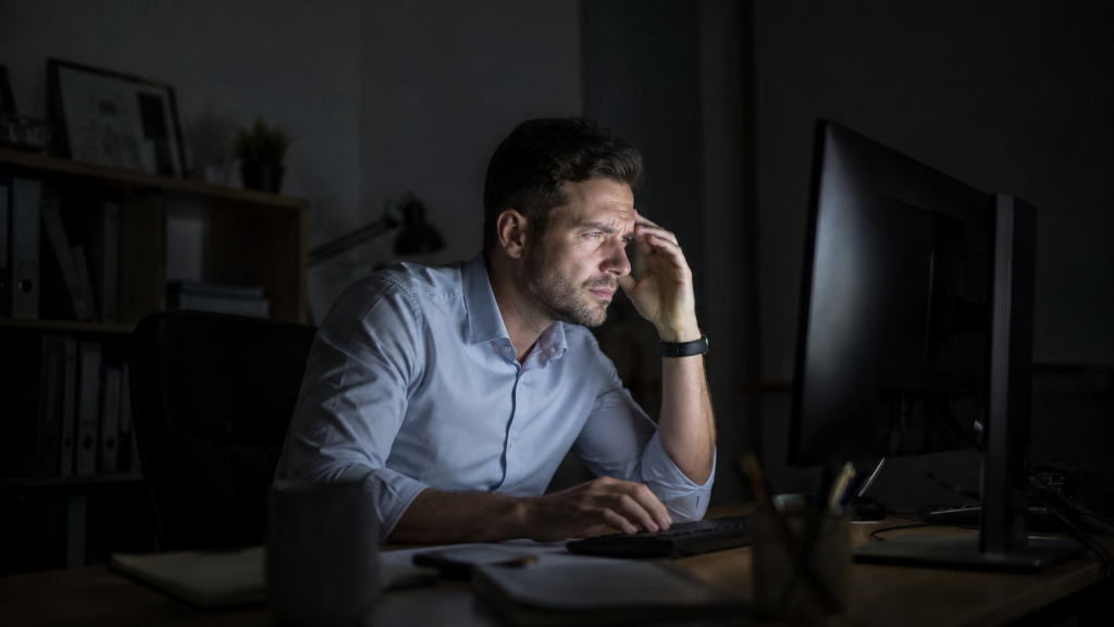 Man struggling to see screen due to low light