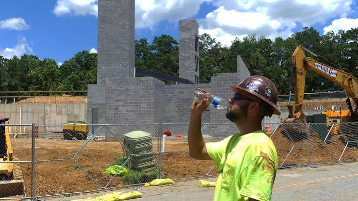 Drinking water at the construction site to cool down from the heat
